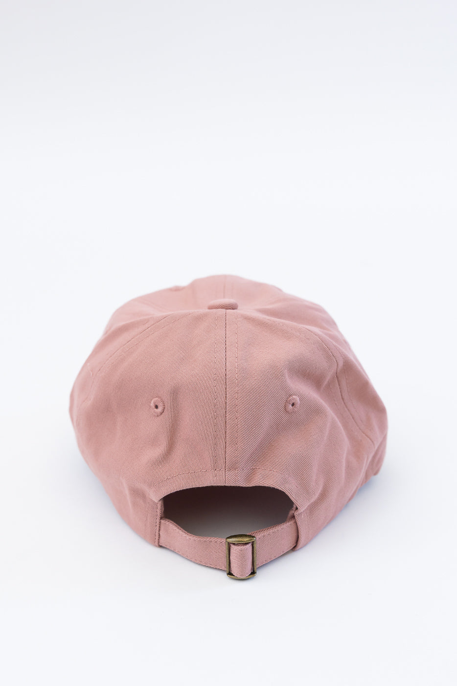 Close-up of the back of a rosewood cotton twill cap with brass adjustable strap.
