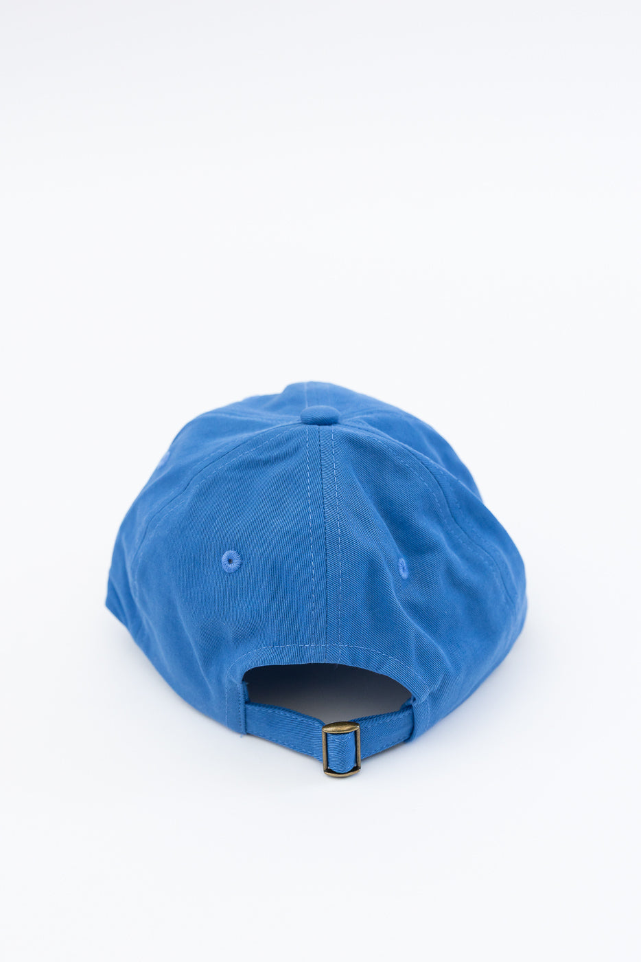 Close-up of the back of a washed blue cotton twill cap showing adjustable strap and stitching.