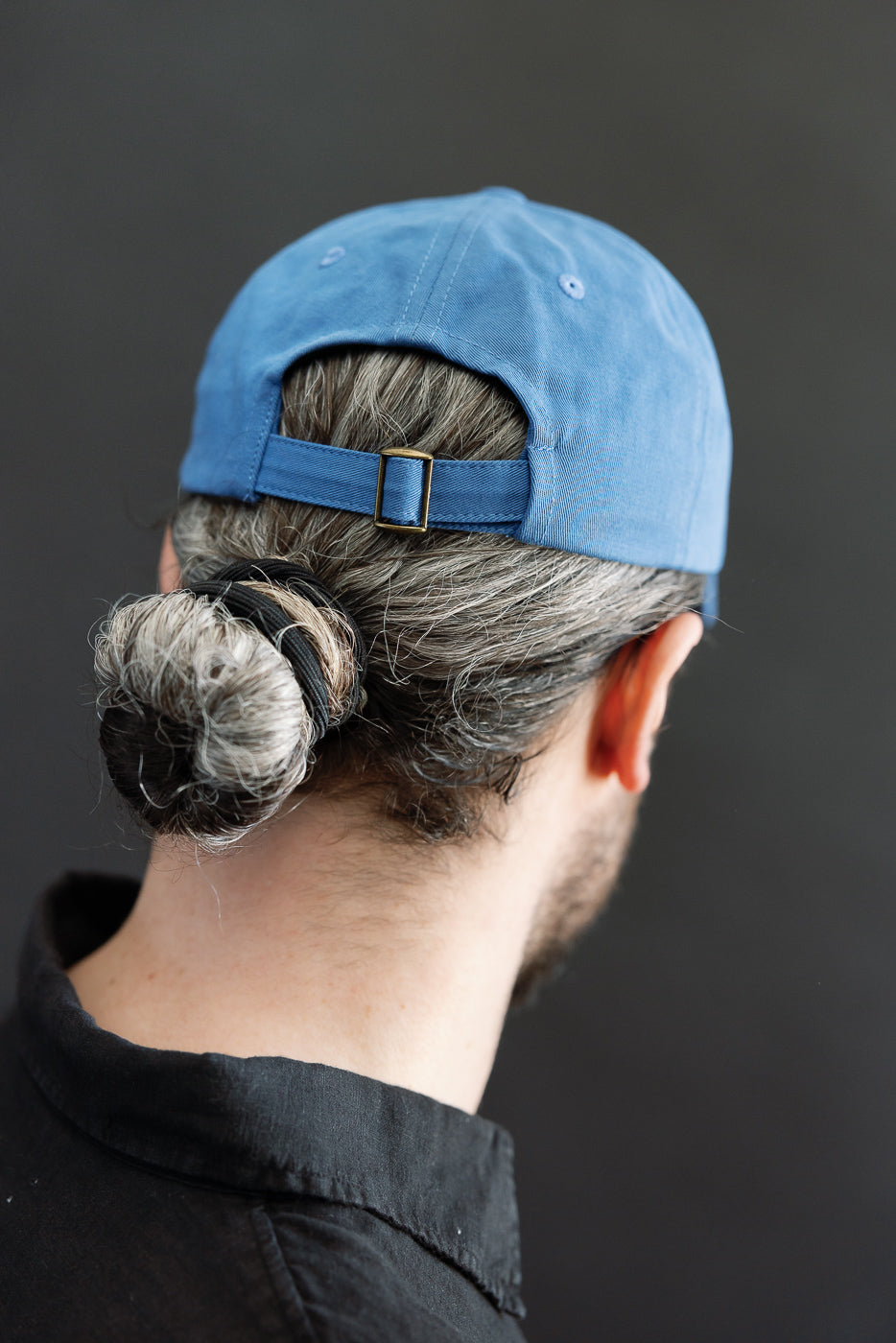 Close-up of the back of a washed blue cotton twill cap on a male model, 5'9