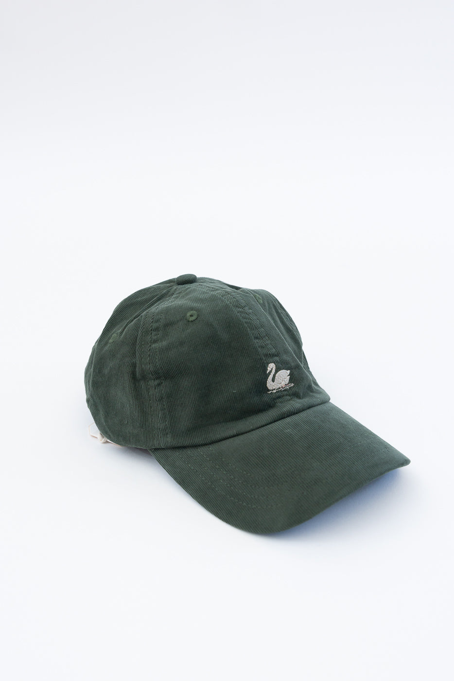 Close-up front view of dark green cotton corduroy cap with embroidered swan logo.