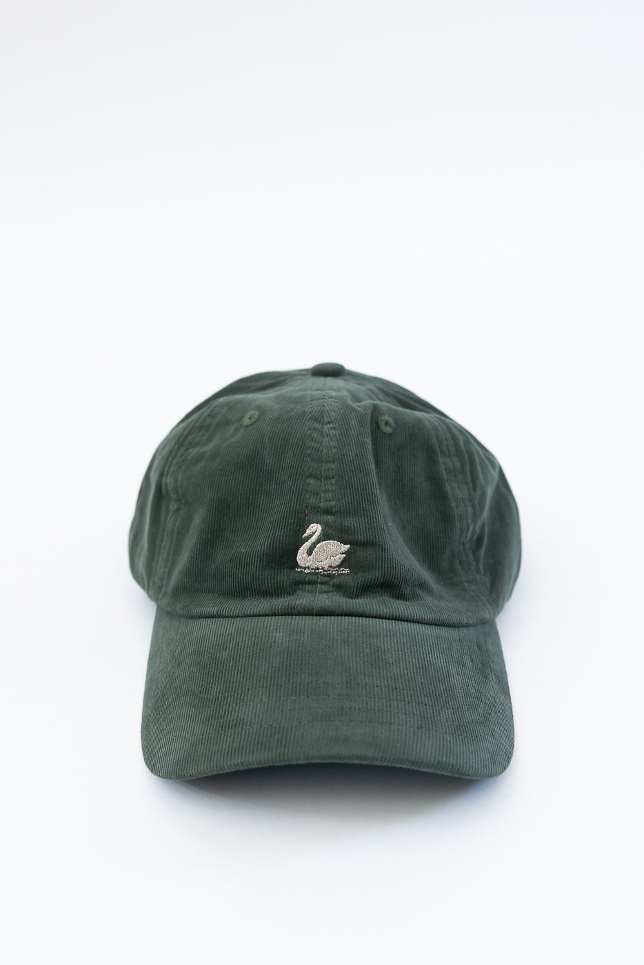 Front view close-up of forest green corduroy cap with embroidered swan logo on crown.