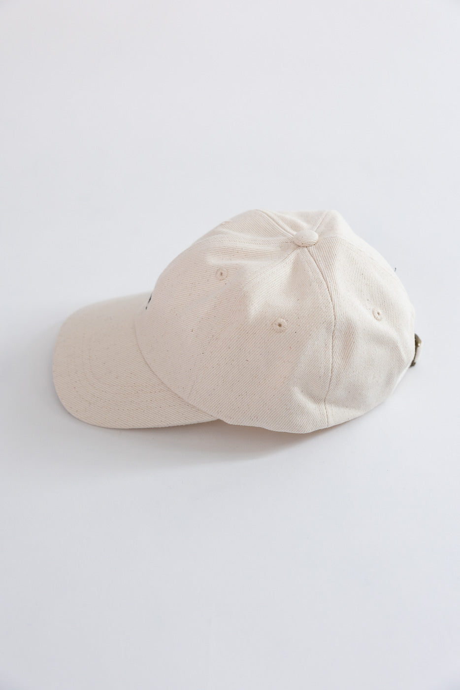 Flat lay of Merz b. Schwanen cotton twill cap in natural color, left back side view.