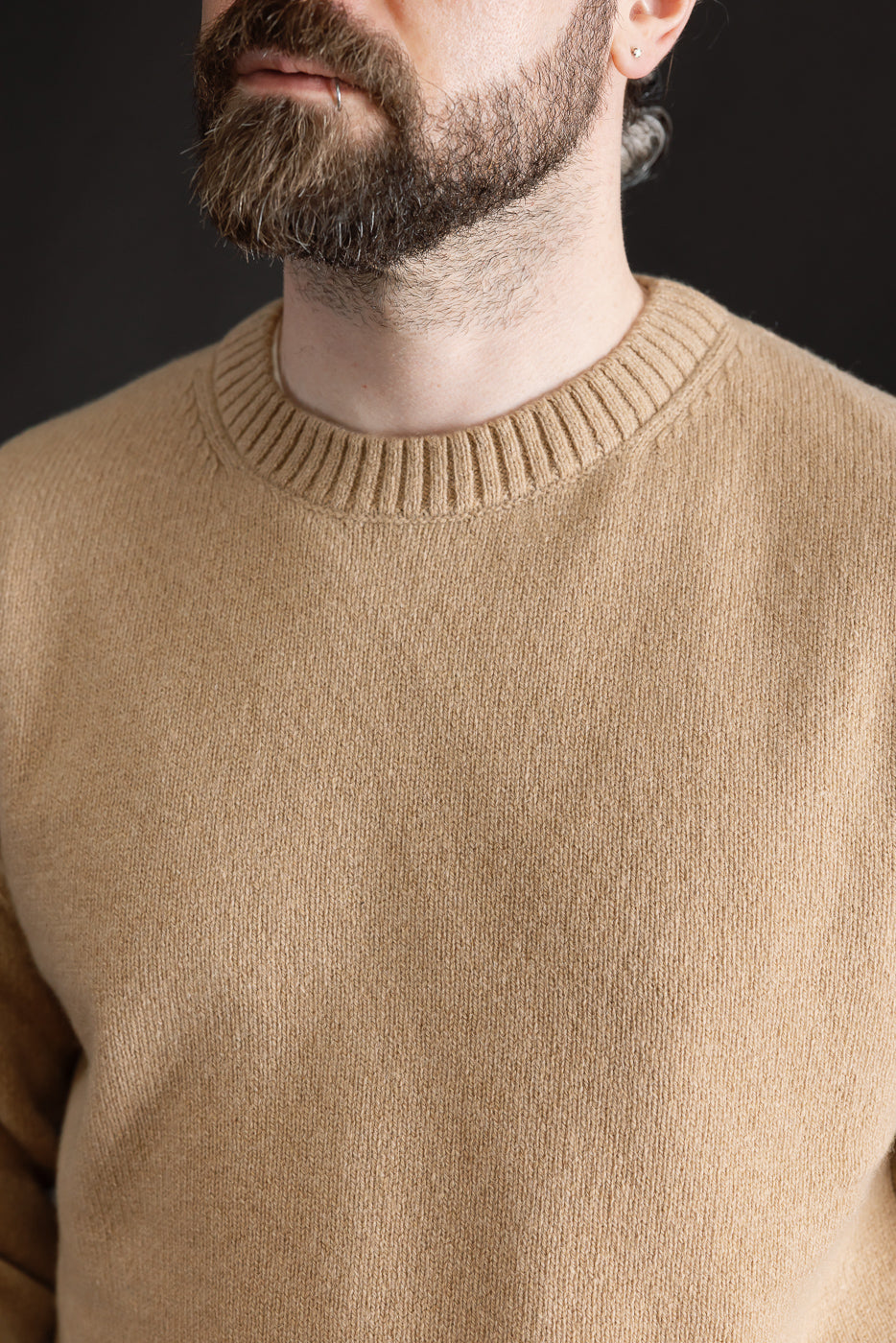 Close-up of front chest and neckline of toffee recycled cashmere sweater on male model, 5'9