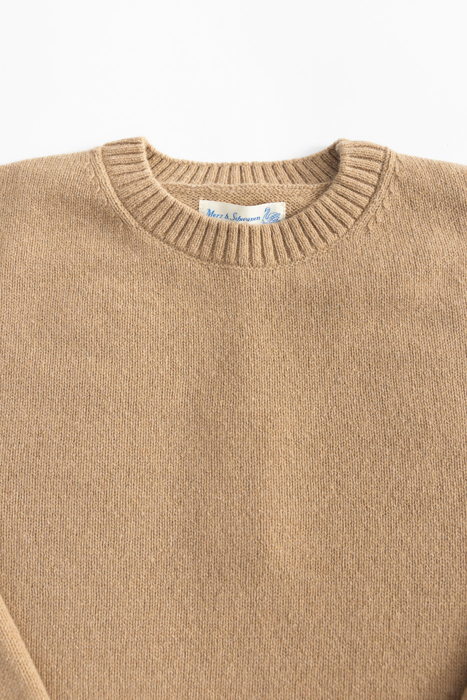 Close-up of front upper section of toffee recycled cashmere sweater, showing ribbed crewneck and fabric texture.