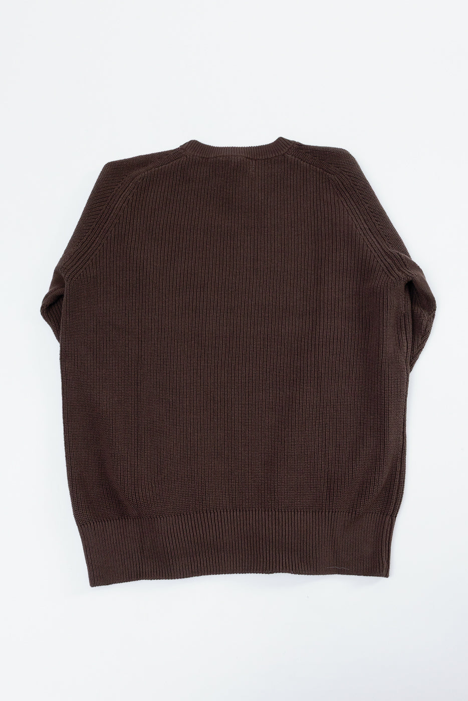 Back view flat lay of a brown ribbed knit sweater showing the textured fabric and hem.