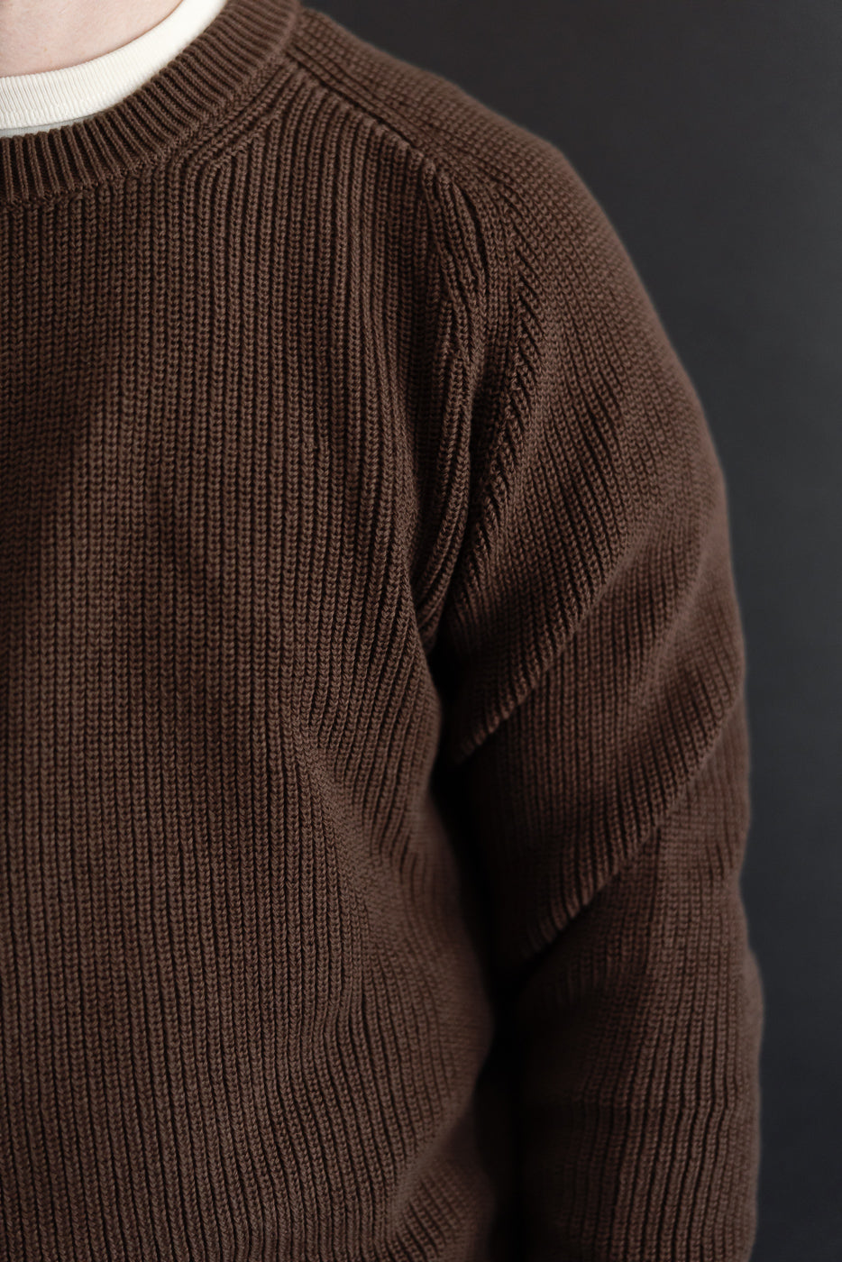 Close-up of the front and left shoulder of a brown ribbed knit sweater.
