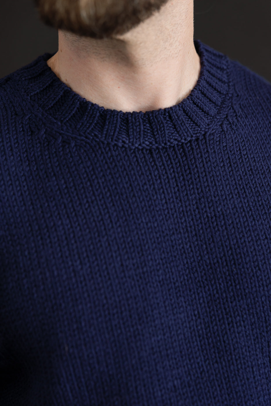 Close-up front view of a navy blue knit sweater collar on a 5'9