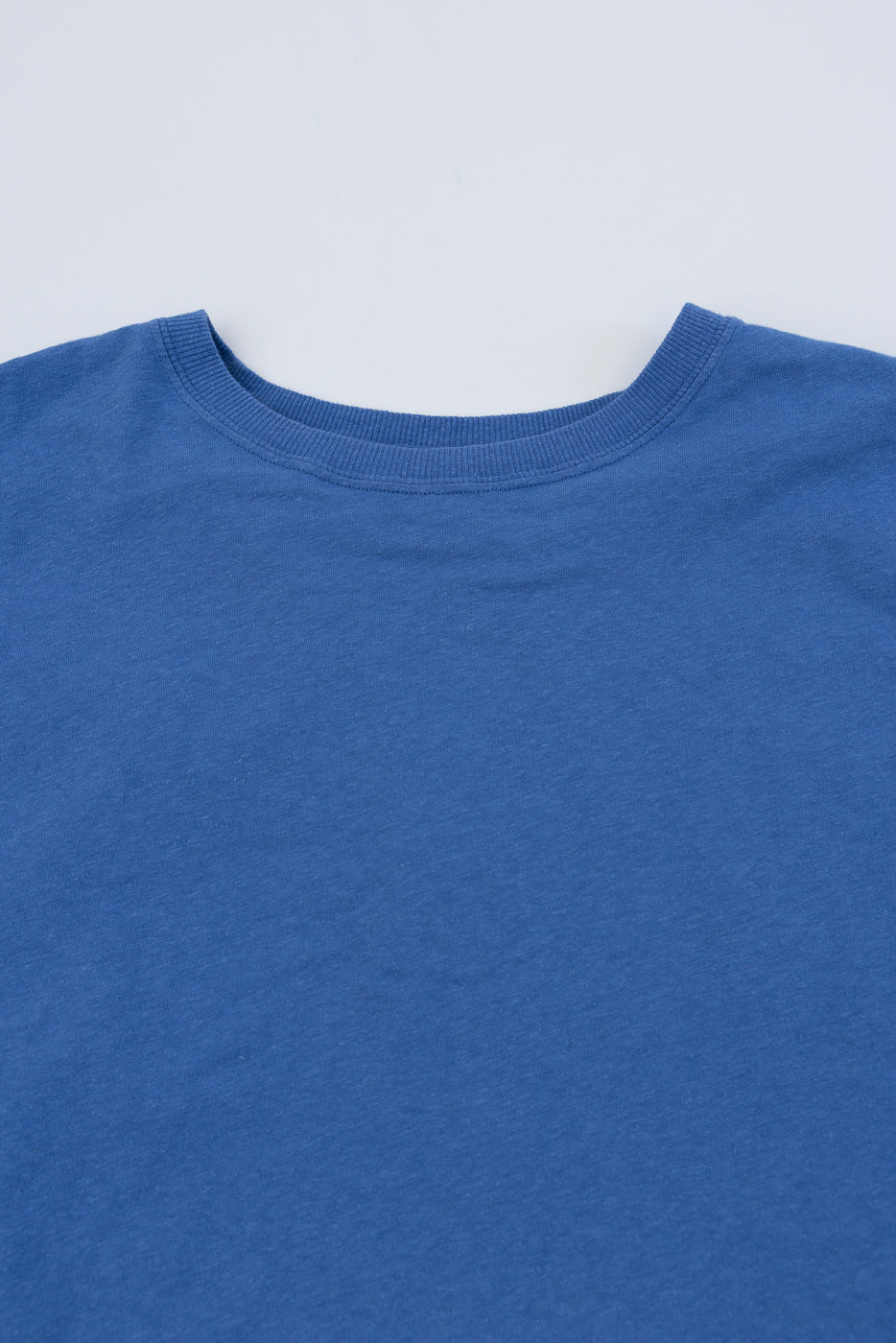 Close-up of faded blue cotton hemp t-shirt, flat lay, front upper chest and collar detail