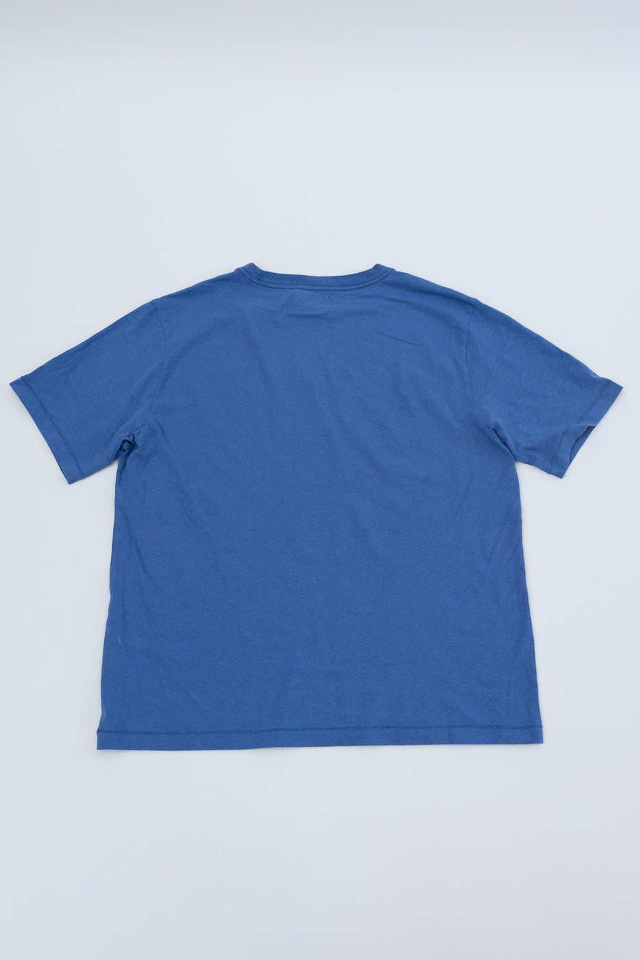 Flat lay of faded blue cotton hemp t-shirt, back view, short sleeves, straight hem.