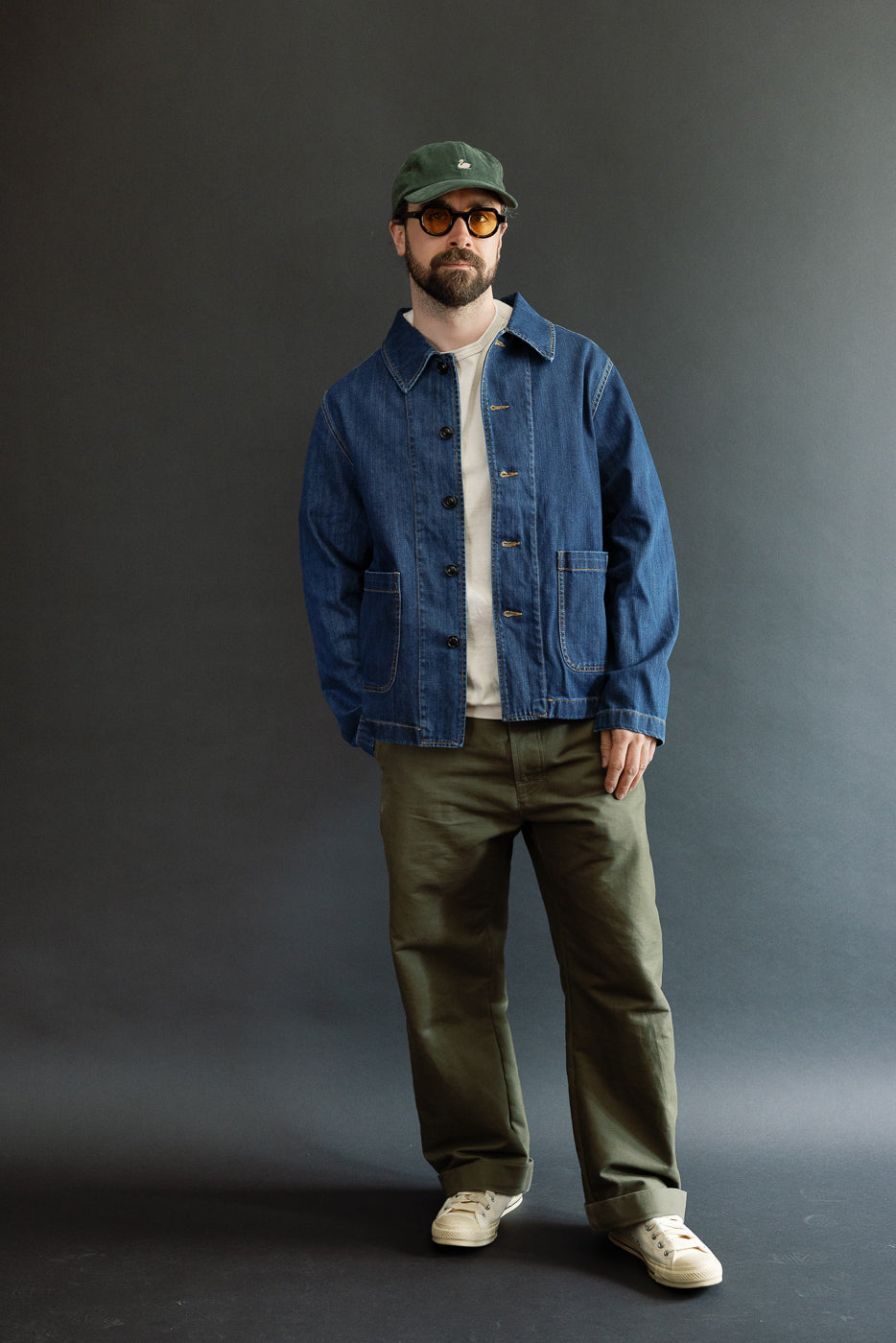 The JKT08DN.520MB Cropped Worker's Denim Jacket, worn by a 5'9 Caucasian male, features a vintage dark wash and two front pockets, embodying refined, timeless workwear style.