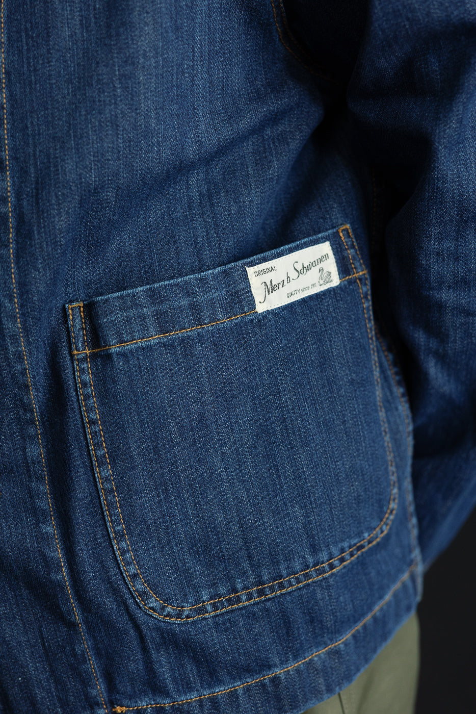 JKT08DN.520MB - Cropped Worker's Denim Jacket - Indigo Mid Blue, featuring contrast orange stitching, a large patch pocket with a label, and a vintage dark wash, showcasing Merz b. Schwanen's craftsmanship.