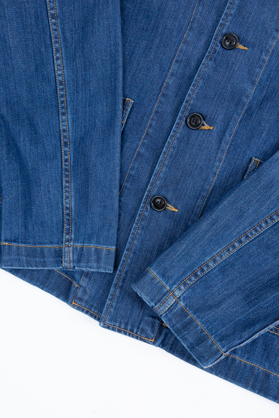 JKT08DN.520MB - Cropped Worker's Denim Jacket in Indigo Mid Blue, showcasing a cropped cut with classic collar, corozo nut buttons, and visible topstitching. Features two front pockets and triangular underarm inserts.