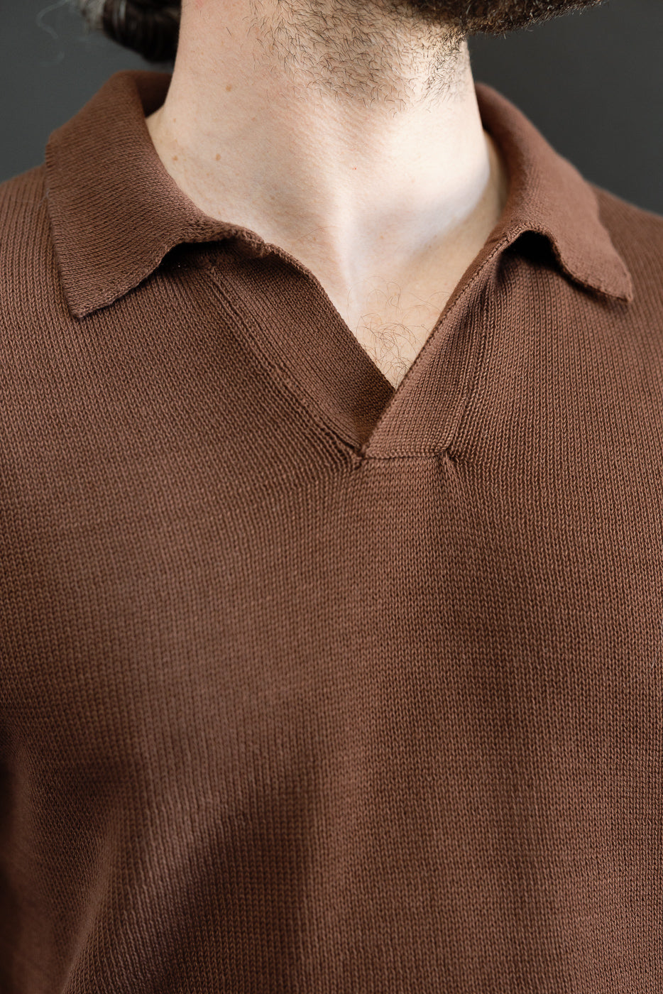 Close-up of the KNITPOLO02.192.7 - Cotton Short Sleeve Polo Shirt, highlighting the brown knitted texture and polo collar with a small open V-neck, showcasing its relaxed style and sustainable craftsmanship.