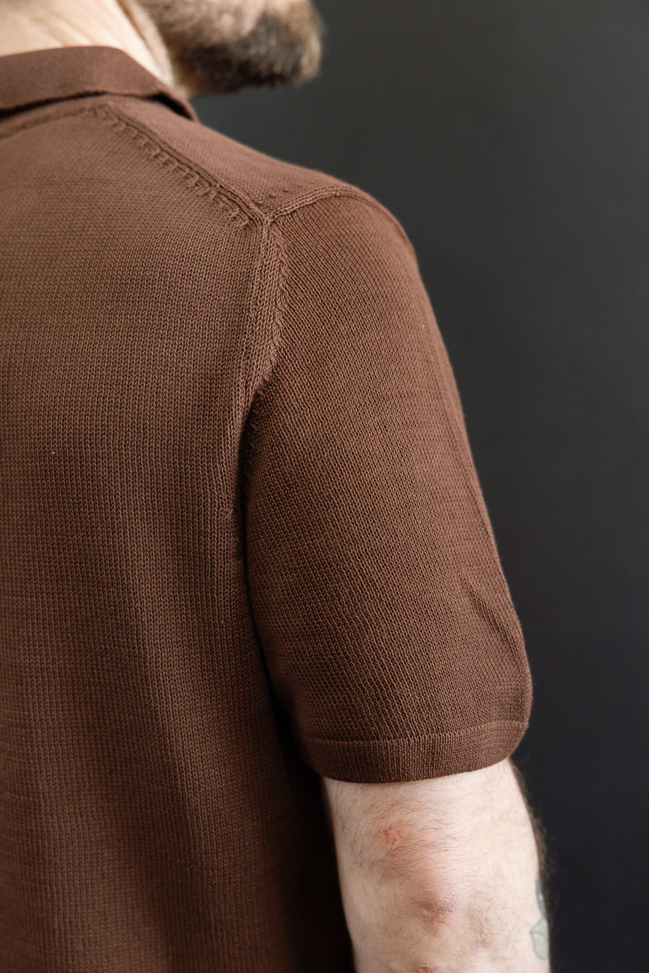 Close-up of the KNITPOLO02.192.7 - Cotton Short Sleeve Polo Shirt, showcasing the fine stockinette-stitch texture and shoulder seam detail in plant-based, organic cotton for a relaxed, sustainable style.
