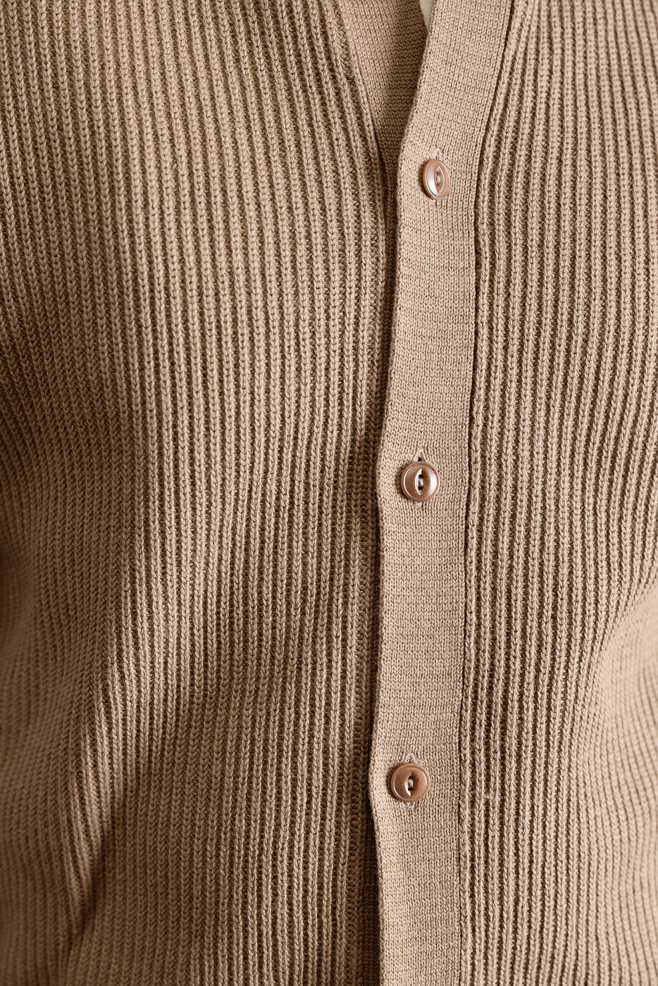 Close-up of front torso, ribbed cotton long sleeve shirt in beige, button details visible, male model, athletic build, 5'9