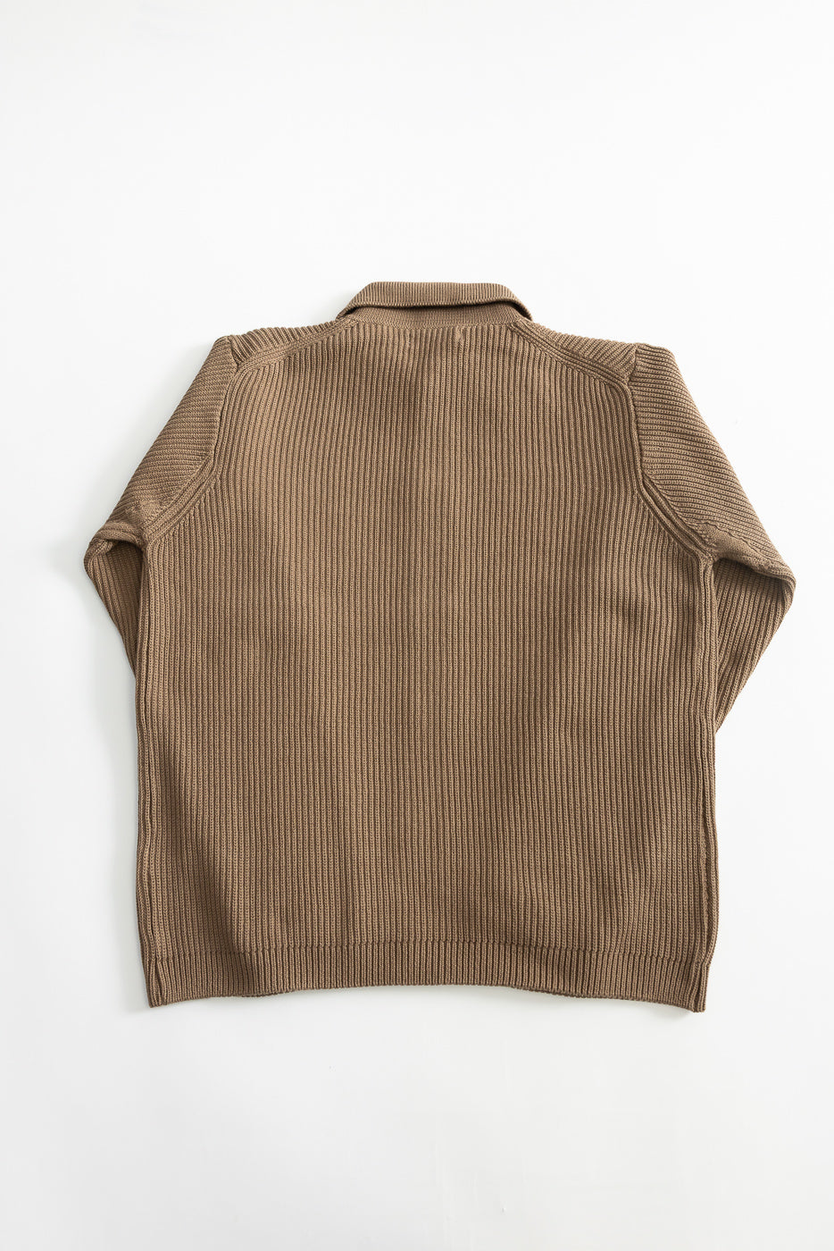 Flat lay of ribbed cotton long sleeve shirt in grain color, back view, showing collar and fabric texture.
