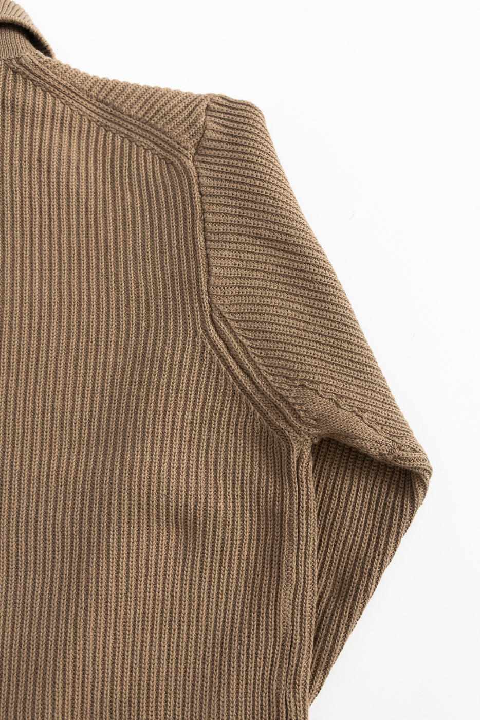 Close-up of ribbed cotton long sleeve shirt, showing right shoulder and sleeve seam detail