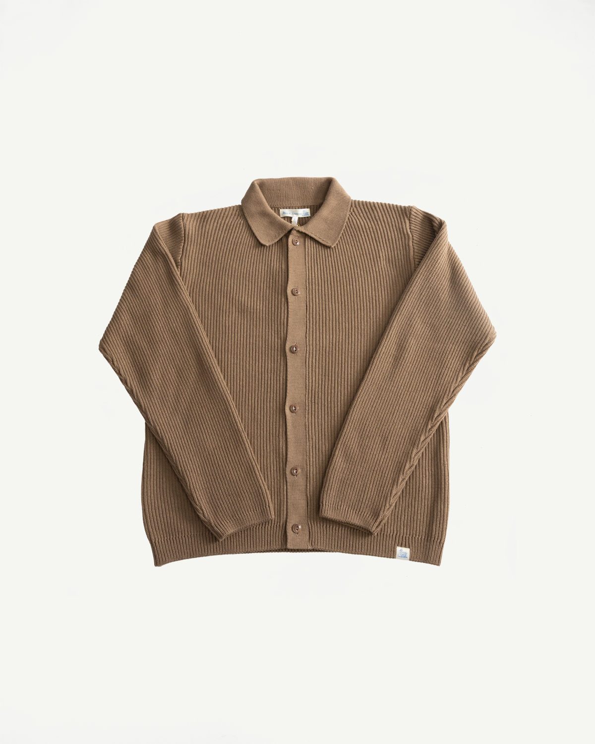 Flat lay, front view of a ribbed cotton long sleeve shirt in tan with buttons and spread collar.