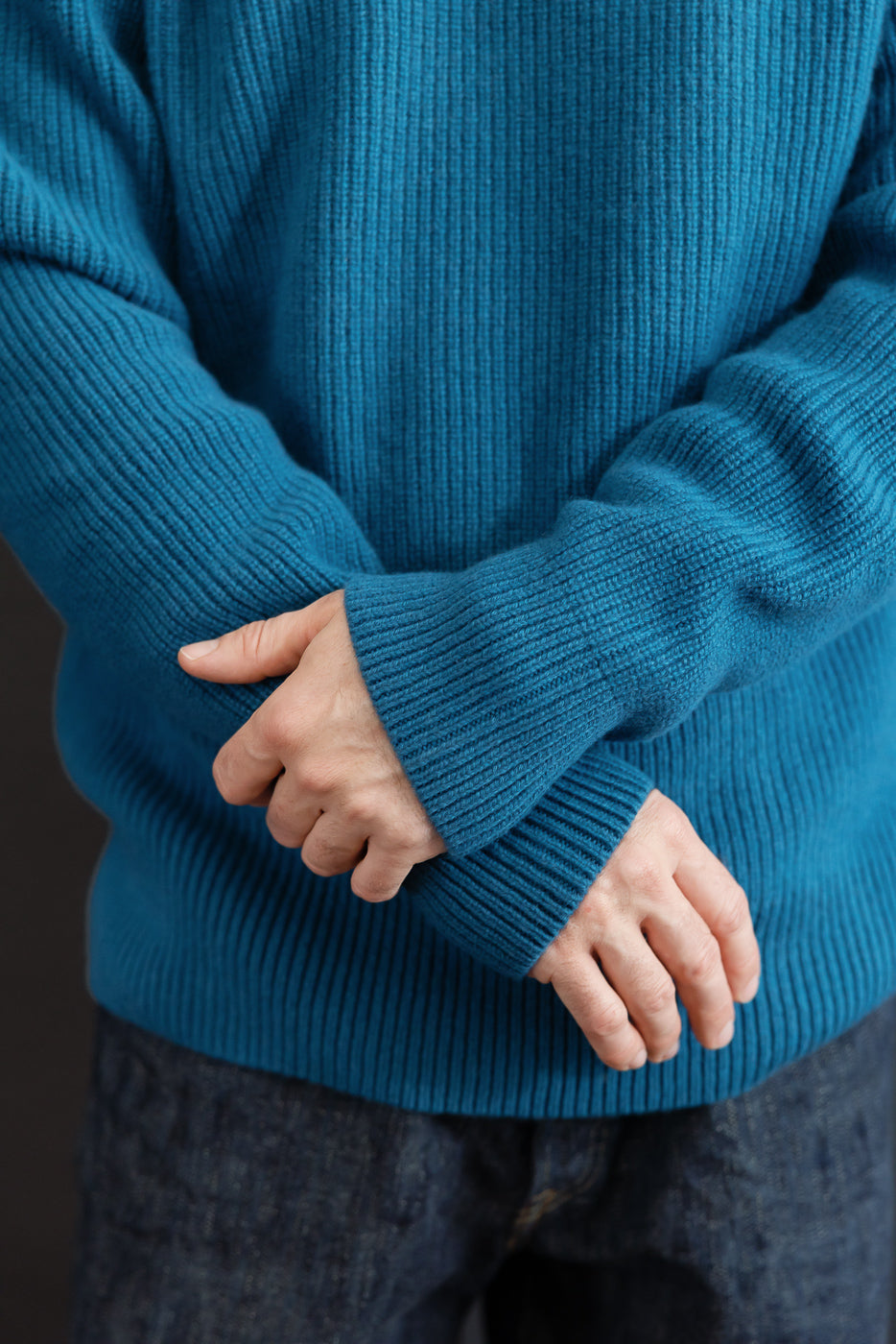 Close-up of blue ribbed sweater sleeve on a male model, 5'9