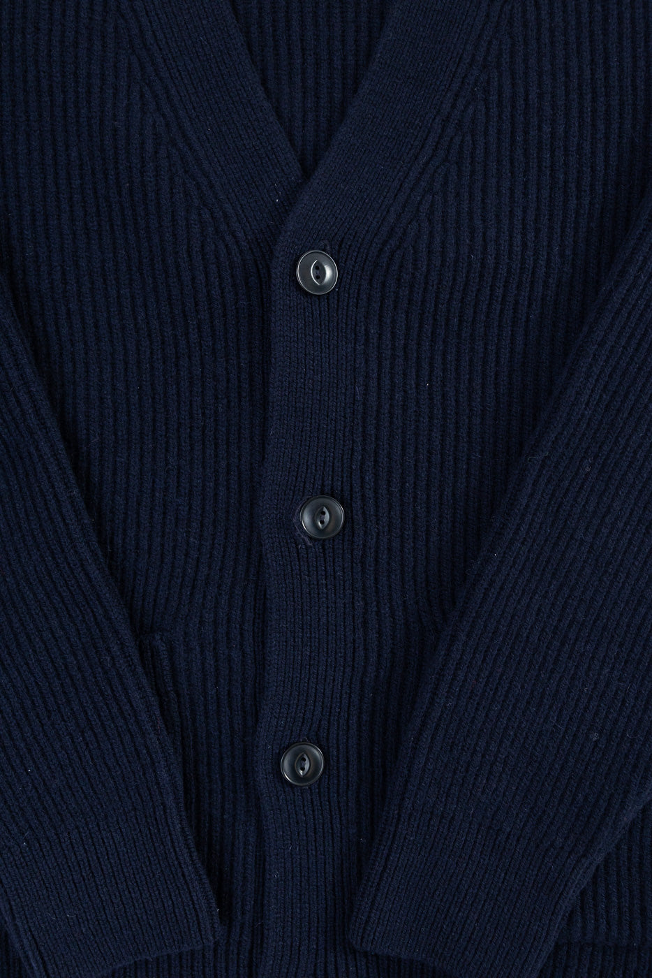 Close-up of front center Merz b. Schwanen navy merino wool cashmere cardigan, showing ribbed knit, buttons, and pocket detail.
