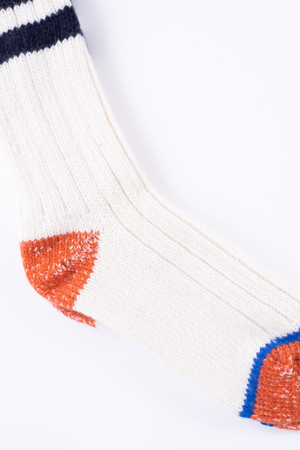 Close-up of Merz b. Schwanen extra fine merino wool sock, showing front side, natural color with ink blue and orange heel and toe details, Dant contemporary casual accessory.