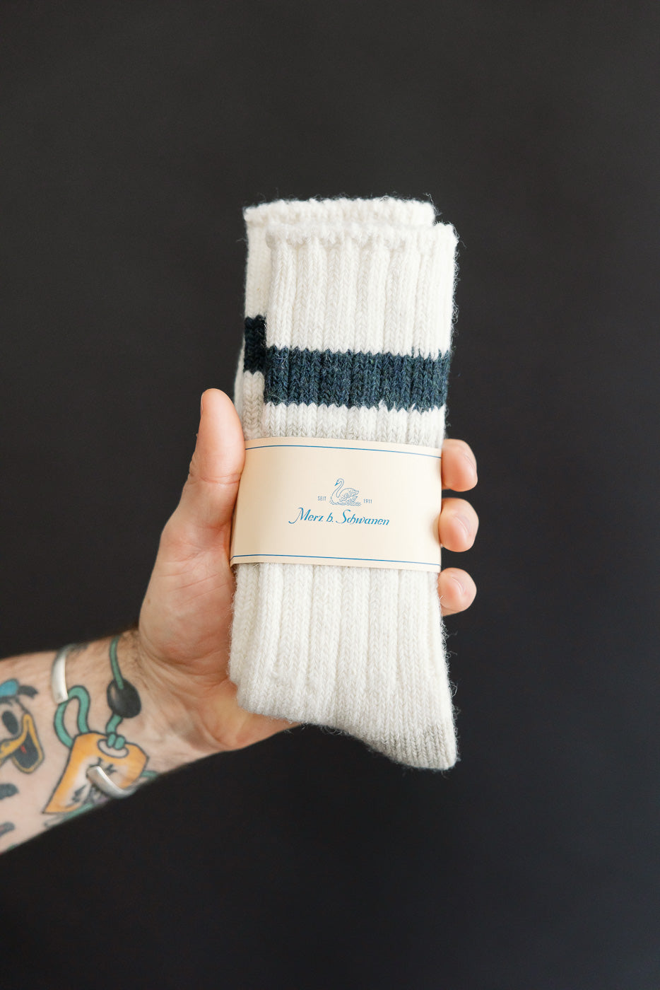 Close-up of Merz b. Schwanen recycled wool socks in nature denim blue, front flat lay in hand