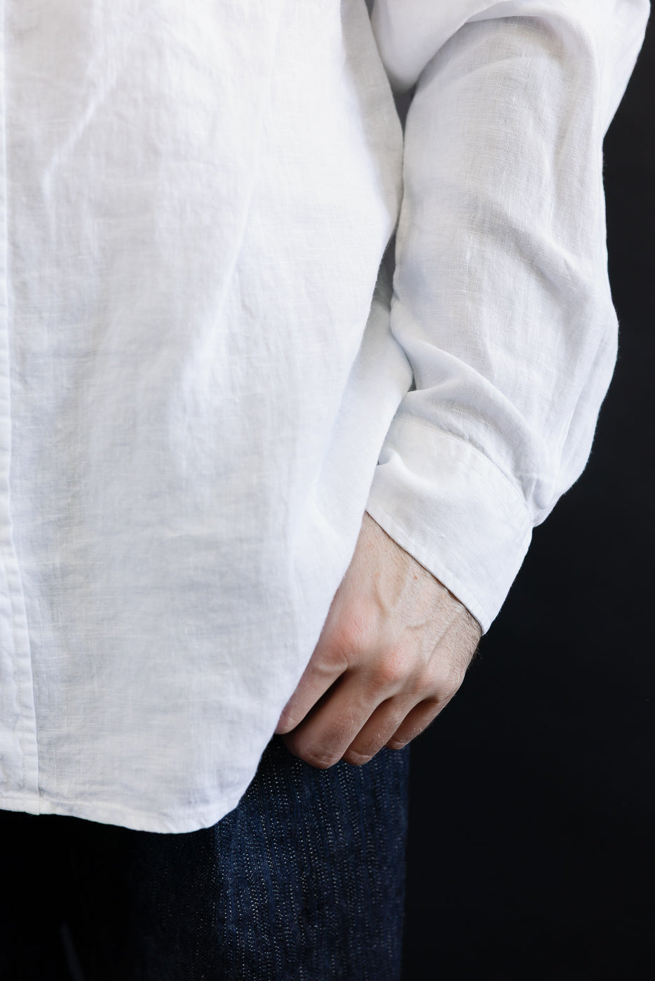 Close-up of front left side of white organic linen long-sleeve shirt on 5'9