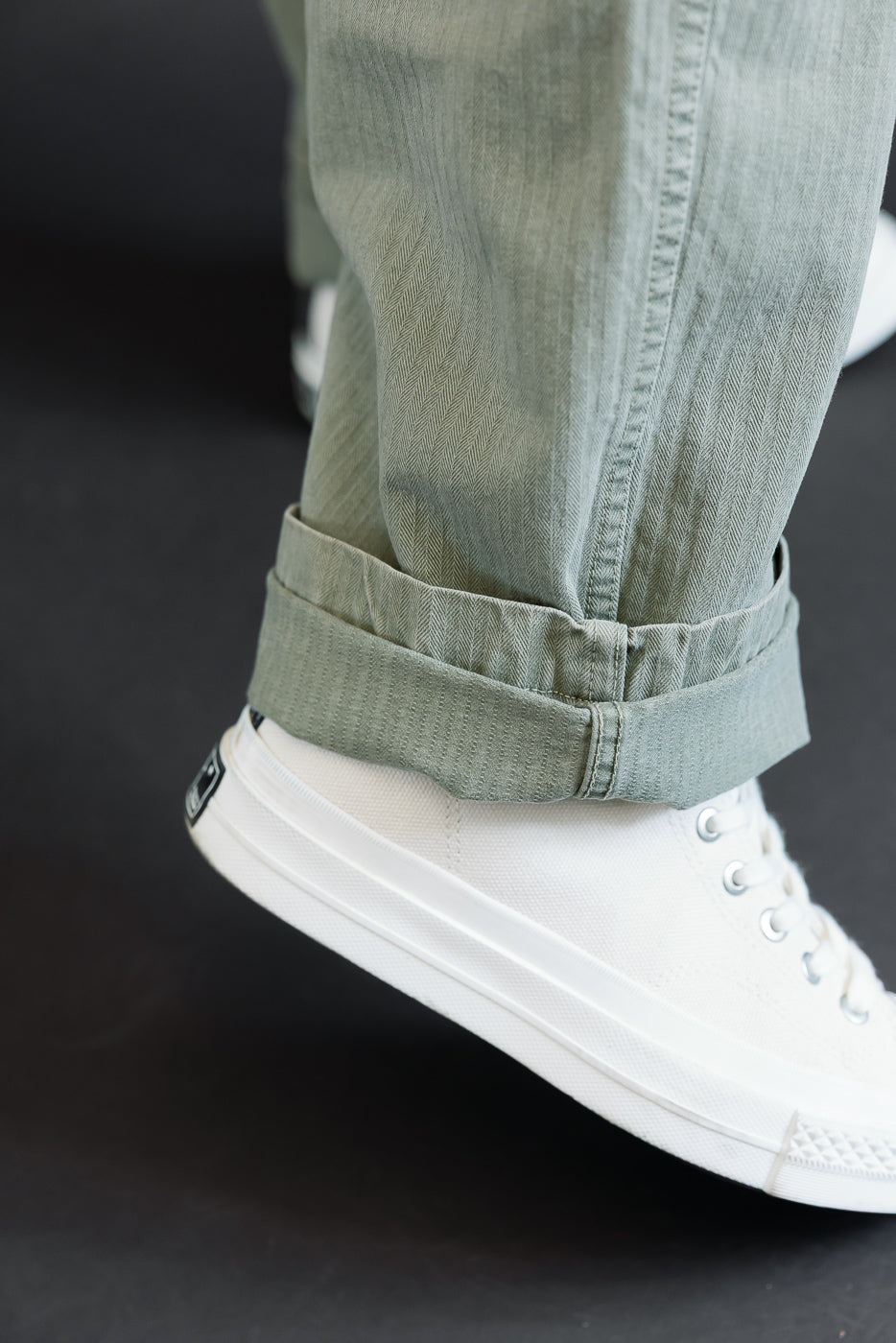 Close-up of cuffed hem on sage green pants worn by a 5'9