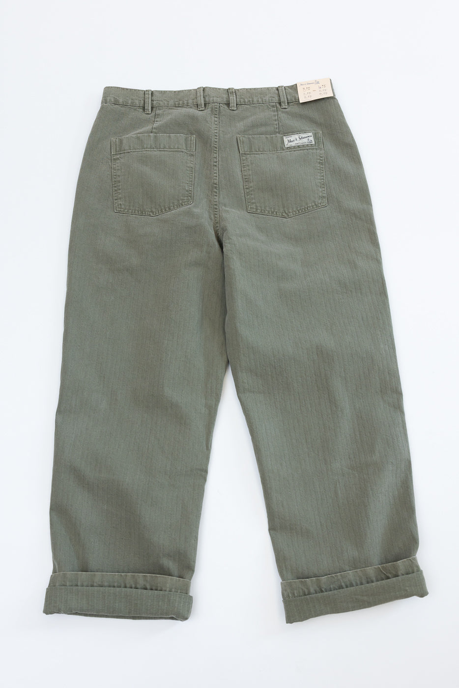 Flat lay of the back of olive green trousers with back pockets and cuffed hems.