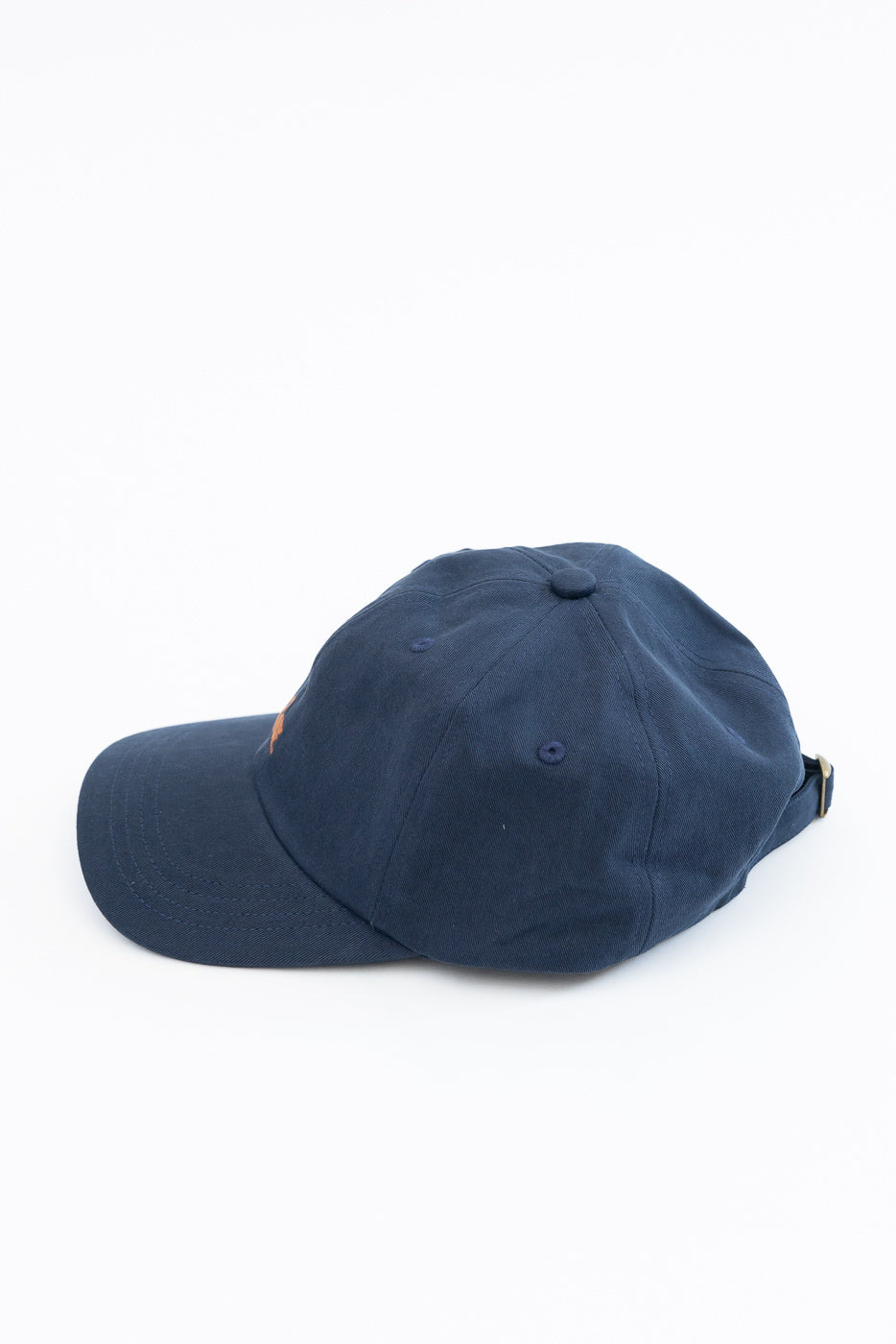 Side view of a navy blue cotton baseball cap on a white background.