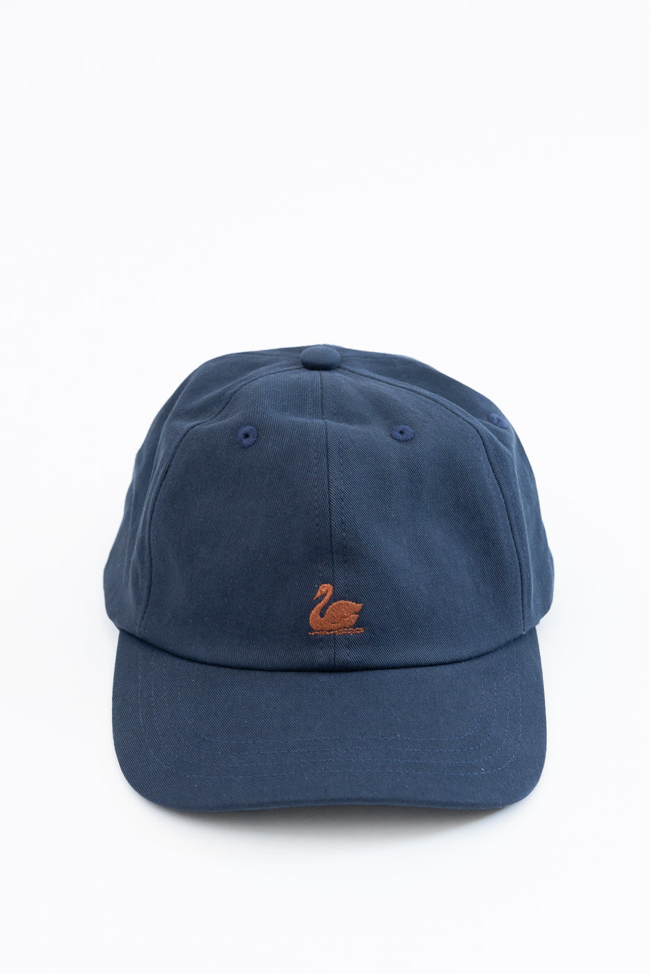 Front view of a navy blue cotton baseball cap featuring an orange swan embroidery.
