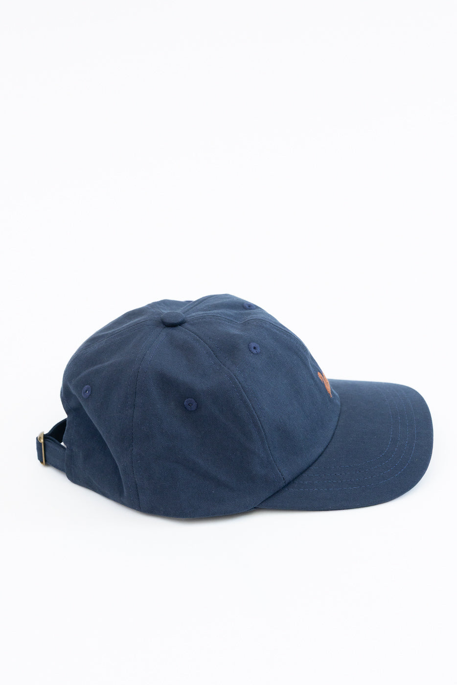 Side view of a navy blue cotton baseball cap on a white background.