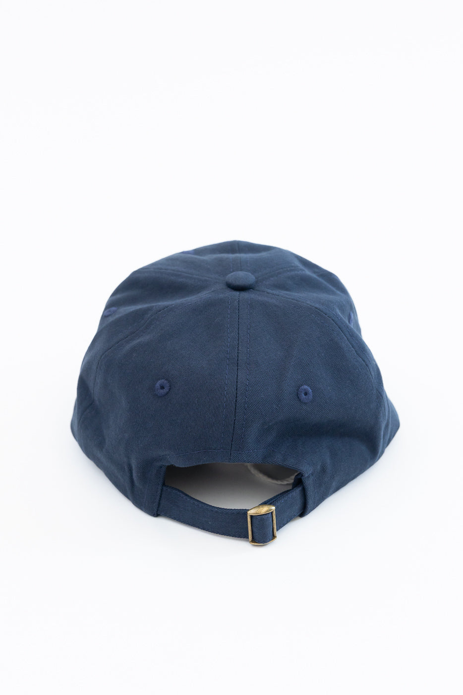 Back view of a navy blue cotton twill baseball cap showing the adjustable strap and buckle.