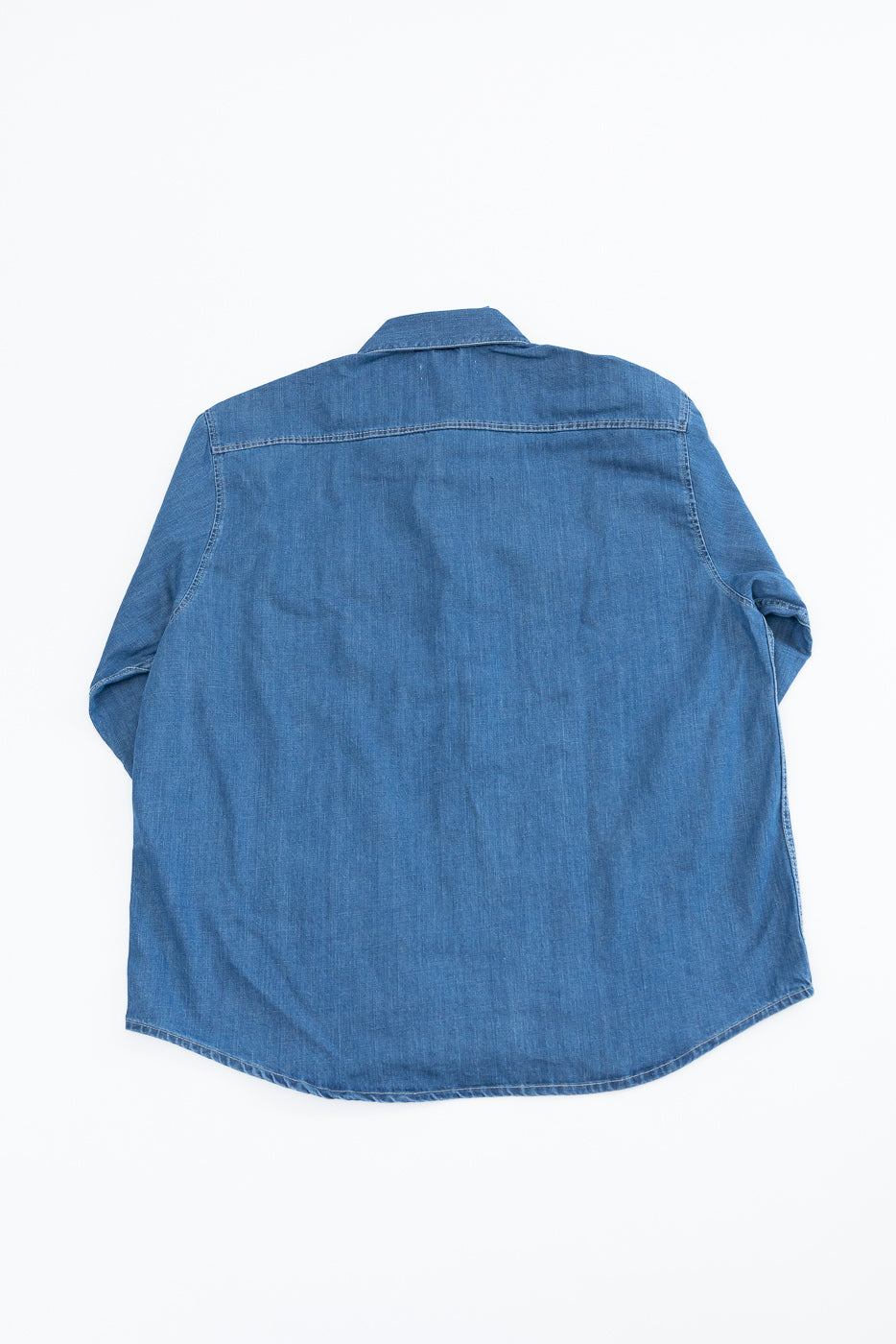 Back view flat lay of a blue denim long sleeve shirt.