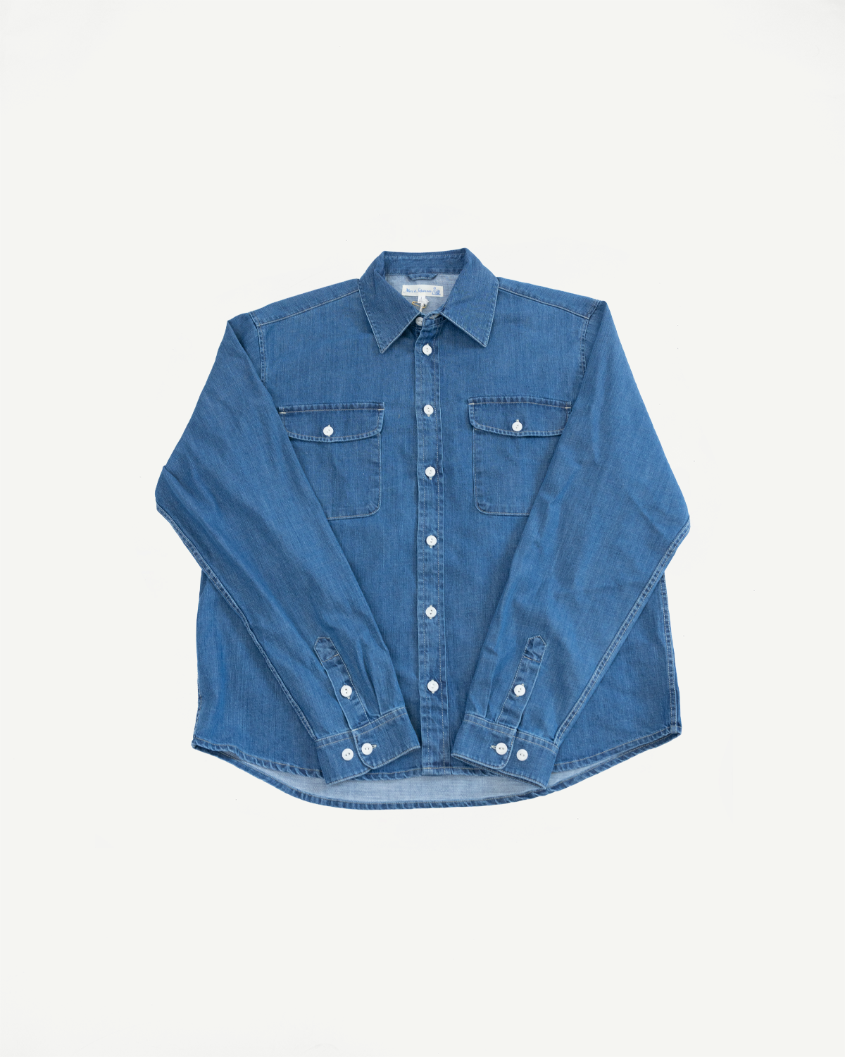 Front view flat lay of a blue denim long sleeve button-down shirt with two chest pockets.