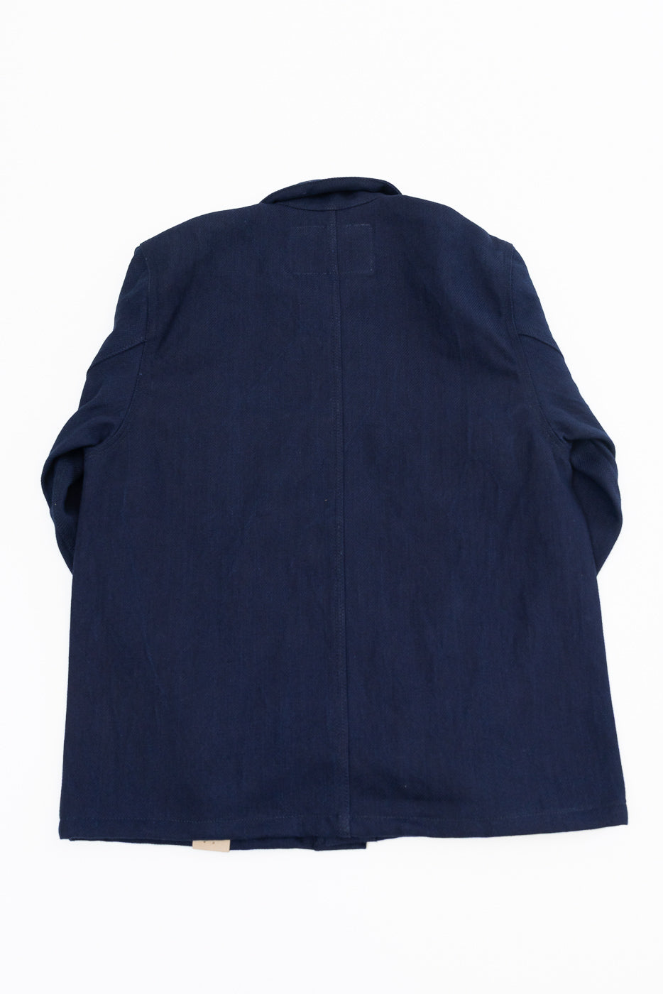 Flat lay back view of navy work jacket, showing center seam, collar, and hem tag detail