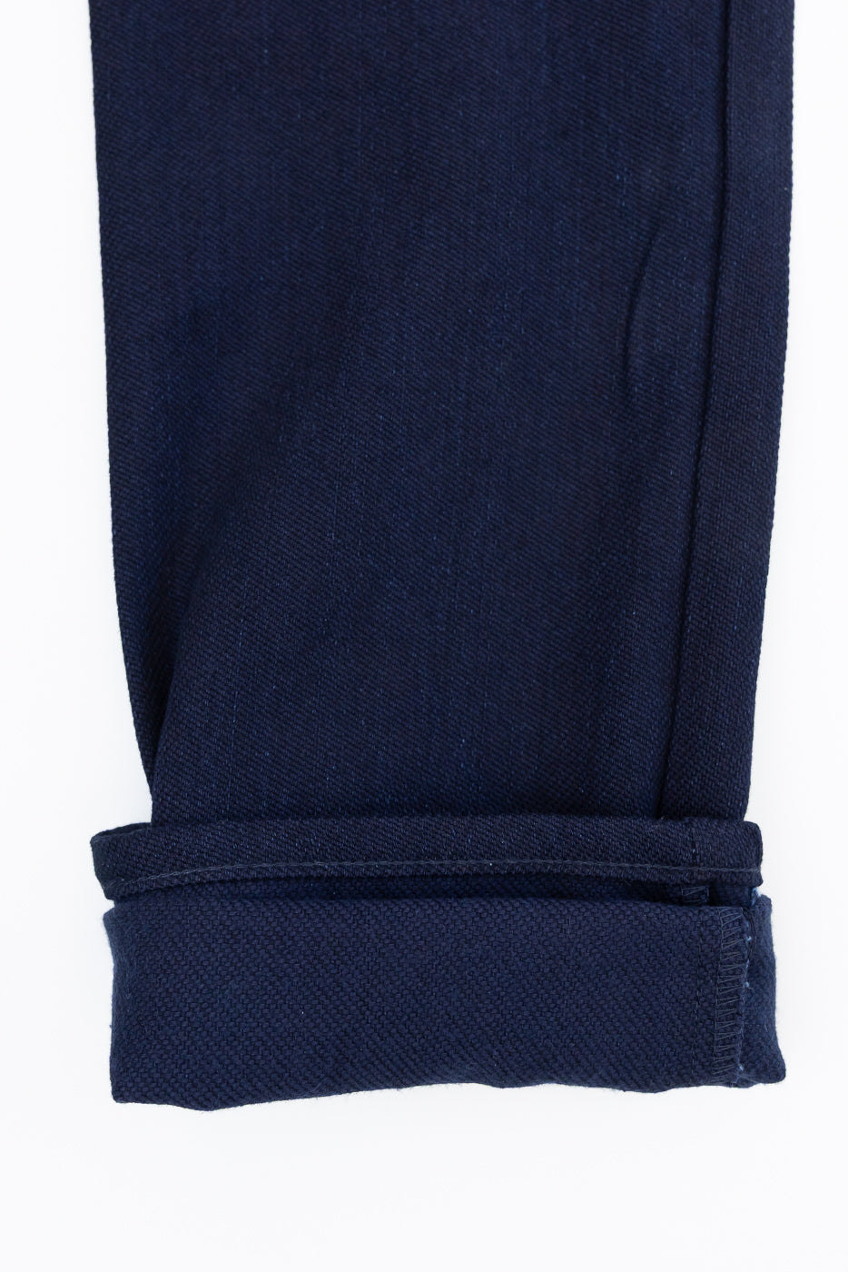Close-up of navy selvedge jeans hem, showcasing fabric texture and rolled cuff detail