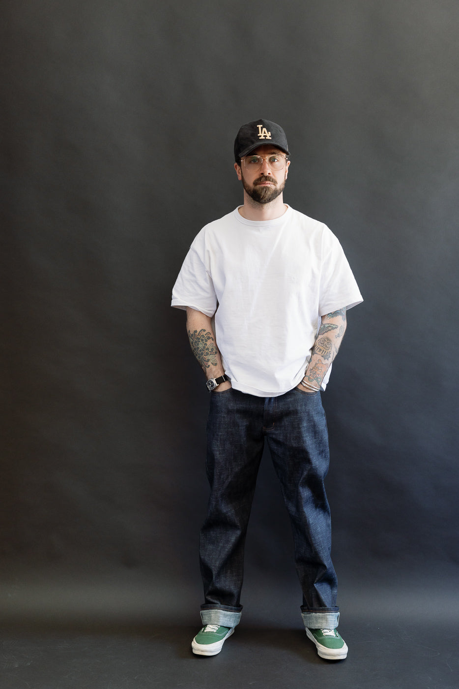 A 5'9 Caucasian male model wearing 12.5oz - Greencast Stretch Selvedge - True Guy jeans, showcasing their straight leg fit and slub texture. The jeans offer a comfortable, stylish look.