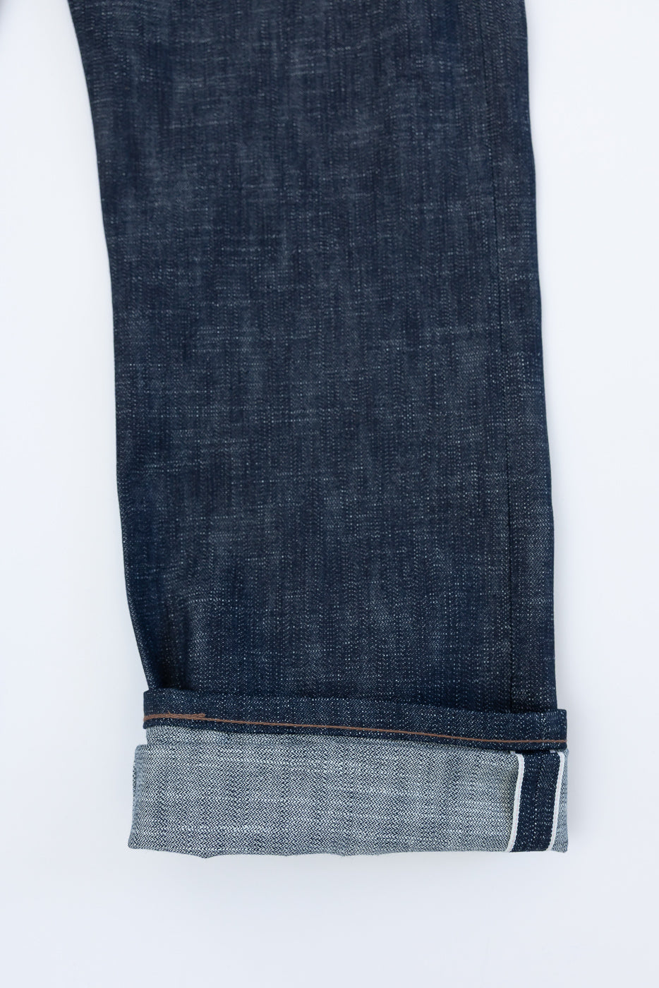 12.5oz - Greencast Stretch Selvedge - True Guy denim showing a rolled hem, revealing the lighter-colored selvedge edge, highlighting the detailed craftsmanship and slub texture of the premium Japanese fabric.