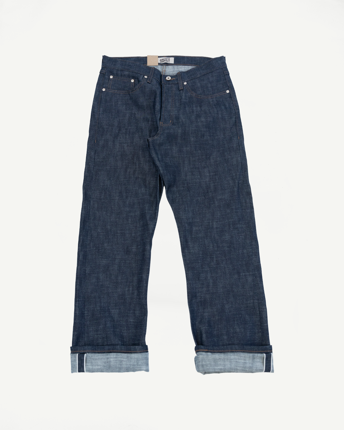 12.5oz Greencast Stretch Selvedge - True Guy jeans in dark indigo, displayed flat with cuffed legs to show lighter selvedge edge, highlighting the unique texture and subtle green cast of the denim.