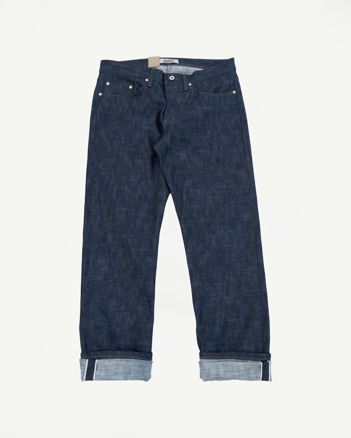 12.5oz Greencast Stretch Selvedge - Weird Guy jeans; dark indigo denim with five-pocket design, contrast stitching, metal rivets, and cuffed hem revealing lighter selvedge edge. Naked & Famous label visible.