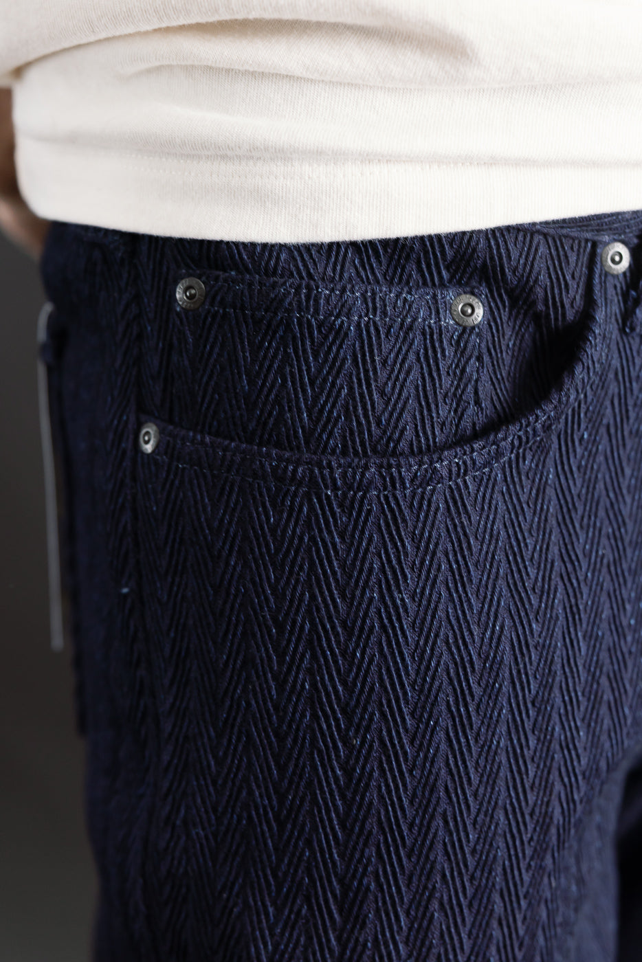 Close-up of men's Naked & Famous indigo selvedge jeans, athletic build, side pocket detail, textured fabric