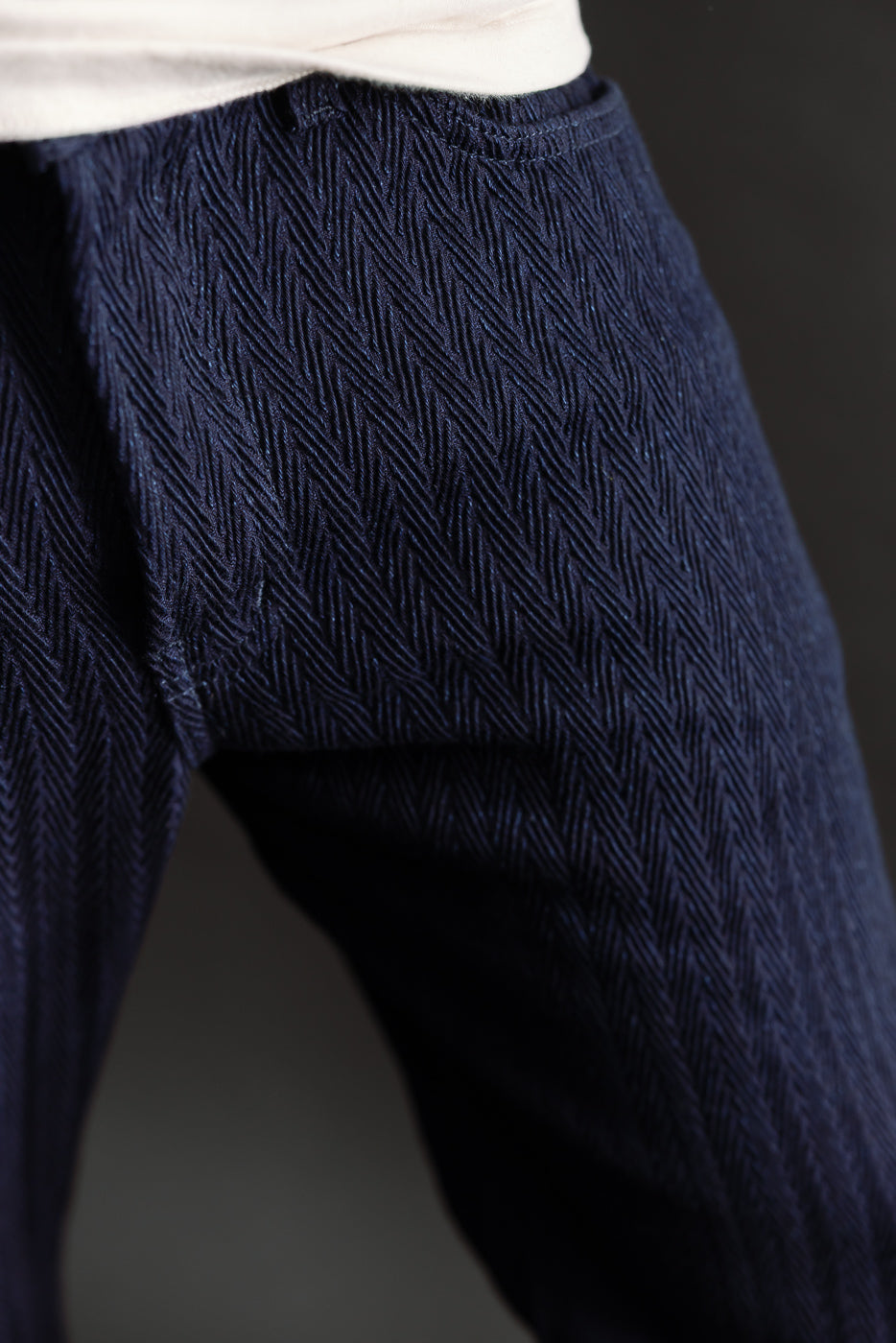 Close-up front view of male model's indigo selvedge jeans with herringbone texture, waist area.