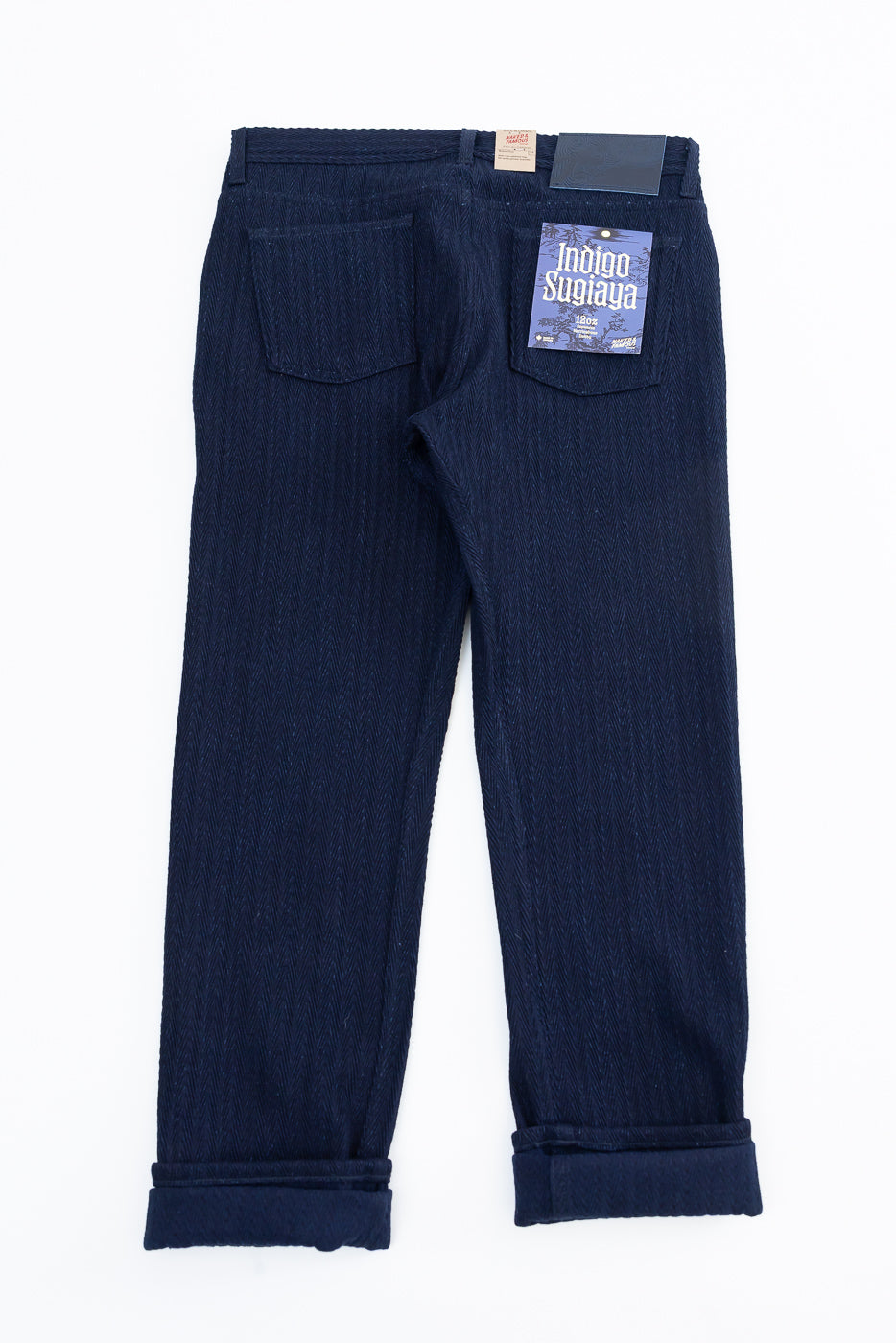 Flat lay of Naked & Famous Indigo Sugiaya jeans, back view showing rear pockets and selvedge tag.