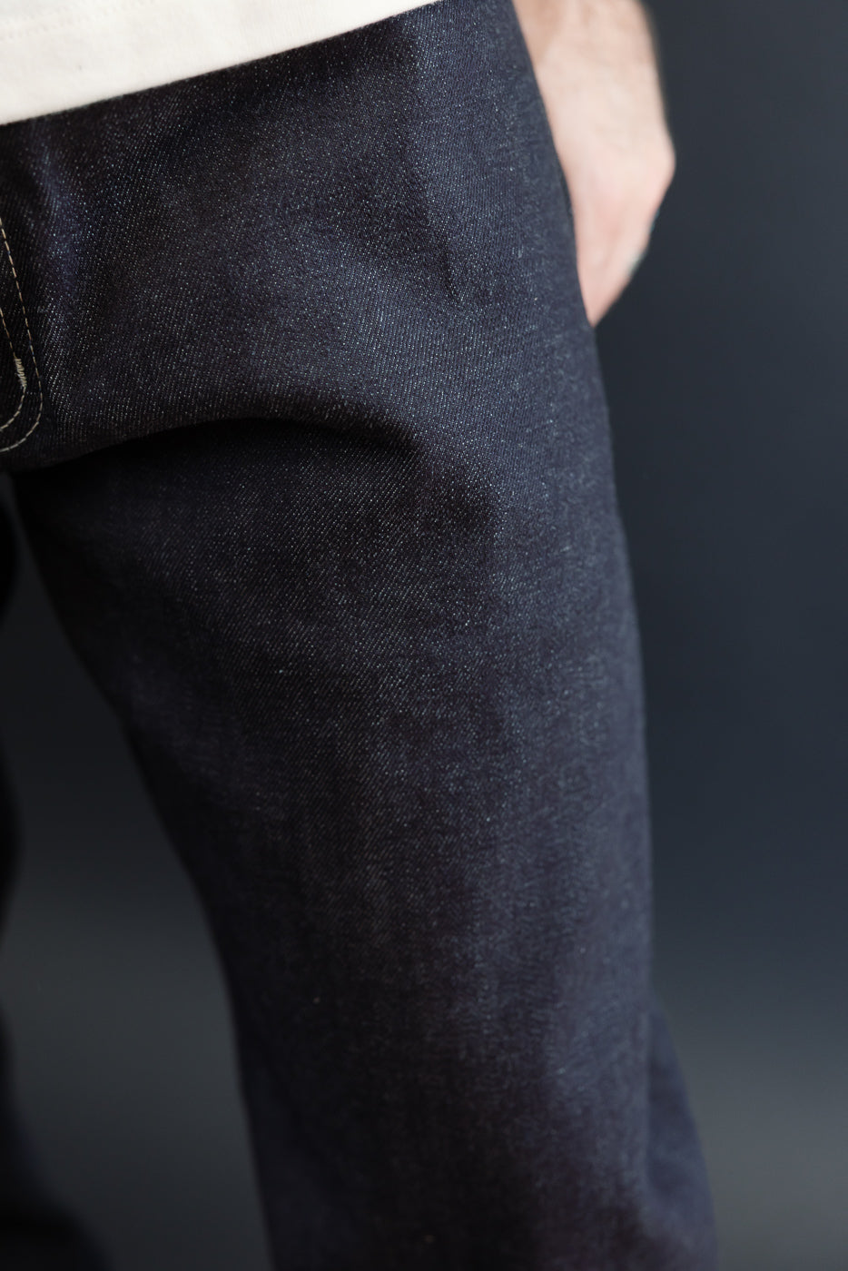 Close-up of dark indigo denim fabric on a male model (5'9
