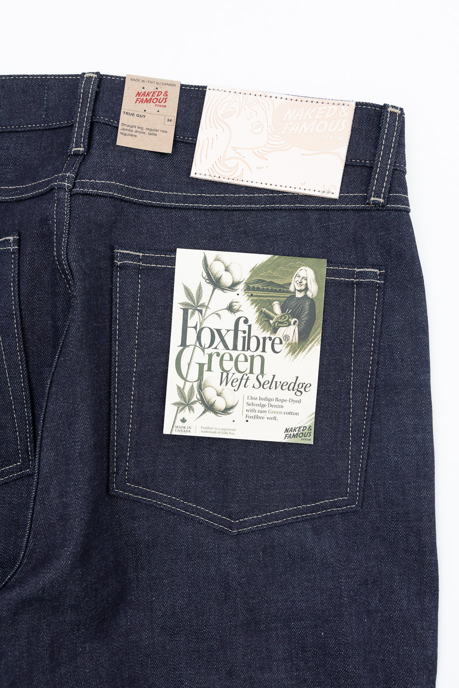 Close-up of the back of Naked & Famous jeans showing fabric texture and product tags.
