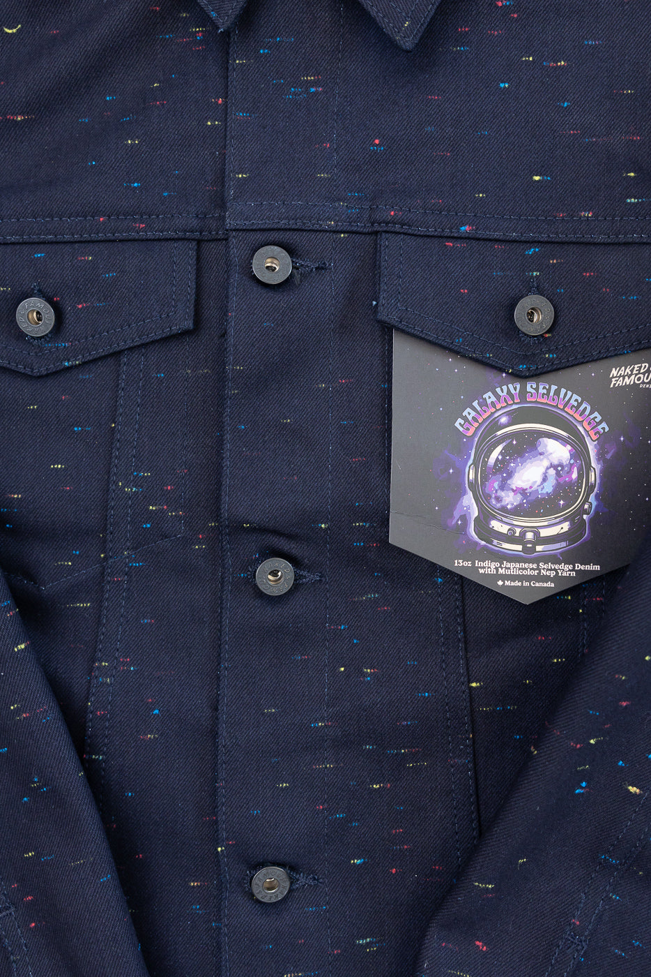 Close-up front view of navy multicolor nep yarn selvedge denim jacket showing buttons and chest pockets.