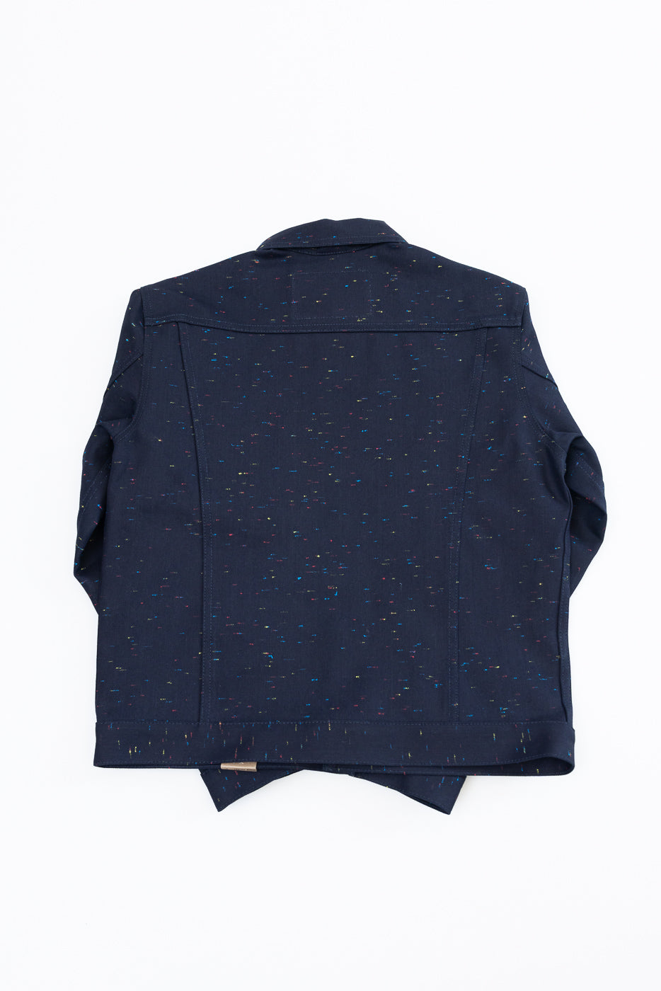 Flat lay of the back of a navy blue speckled jacket with a pointed collar.