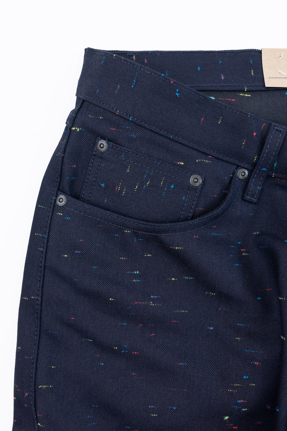 Close-up front view of navy blue textured denim pants showing fabric pattern and pocket detail.