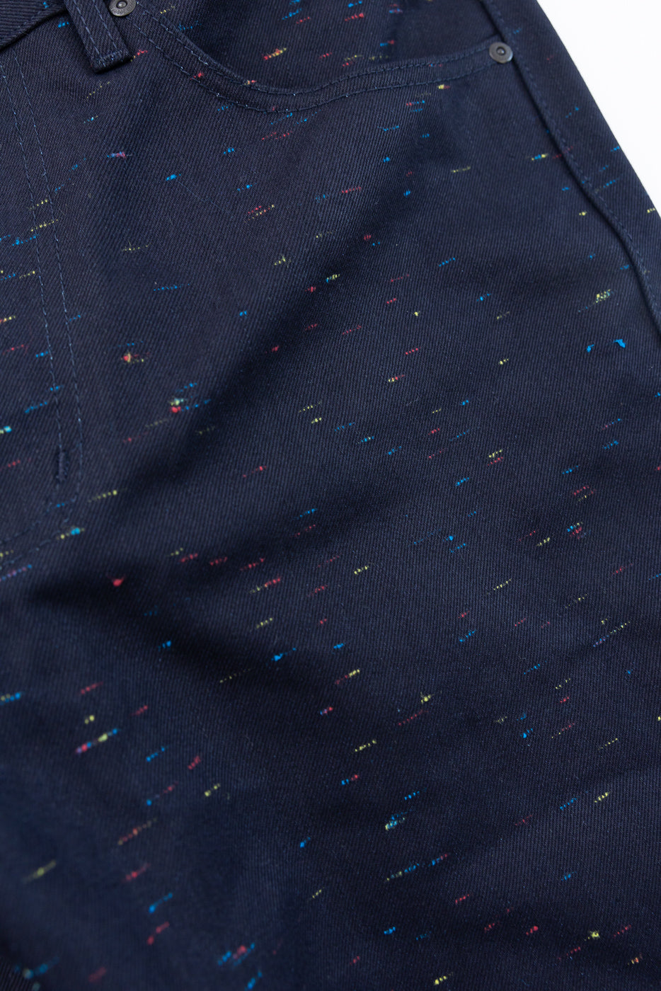 Close-up of the front fabric texture and pocket detail on navy patterned trousers.